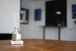 a glass bottle with straws in it on a table at The Lantern Luxe Retreat in Johannesburg