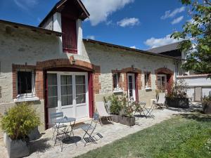 a house with chairs and a table in the yard at La Renardière in Bourges