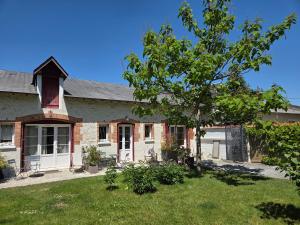 a brick house with a tree in the yard at La Renardière in Bourges