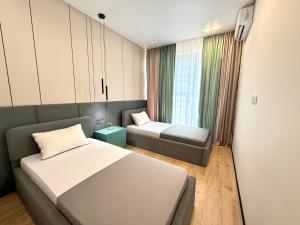 a room with two beds and a couch and a window at ЖК КРИСТАЛЛ Бизнес класс in Almaty