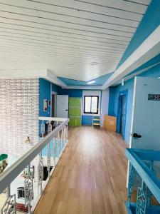 an empty room with blue and green walls and a staircase at Beach Stay Guesthouse in Busan