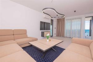 a living room with a couch and a table at Villa Serena Luxury Seafront Escape with Pool in Privlaka