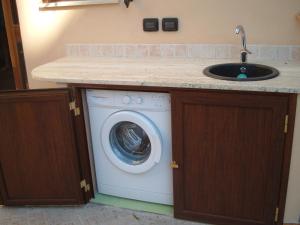a washing machine in a kitchen with a sink at Casa del dottore in Cefalù