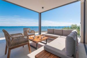 a living room with a couch and a table at Villa Serena Luxury Seafront Escape with Pool in Privlaka