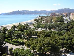een uitzicht op een strand met palmbomen en de oceaan bij Elle's House in Savona