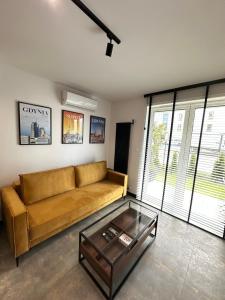 a living room with a couch and a glass coffee table at Apartament Modesta Przy Aquaparku Reda in Rumia