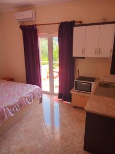 a bedroom with a bed and a kitchen with a microwave at Villa Selmani in Ksamil +37 photos