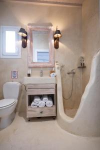 a bathroom with a sink and a toilet and a mirror at Almyra Home in Ornos