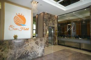 a lobby of a sun hotel with a sign on the wall at Sun Hotel in Durrës