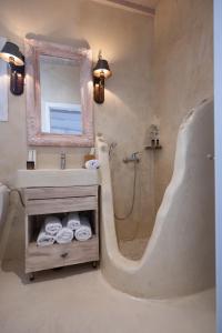 a bathroom with a shower and a sink and a mirror at Almyra Home in Ornos