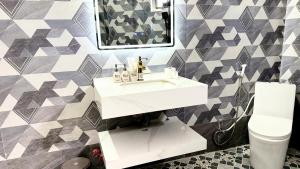 a bathroom with a sink and a mirror and a toilet at Gành Đá Đĩa Retreat Hotel in Tuy An