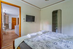 Un dormitorio con una cama y un televisor de pantalla plana. en Boroka Apartman, en Budapest