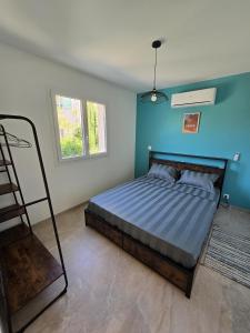 a bedroom with a bed with a blue wall at Cocoon Luberon in Lauris