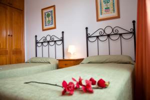 Dos camas con rosas rojas en un dormitorio en Villas Costa Papagayo, en Playa Blanca