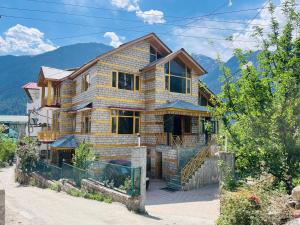 una casa in legno con montagne sullo sfondo di Could 9 cottage a Manāli