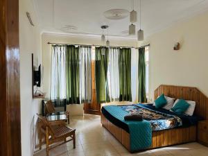 una camera da letto con un grande letto con tende verdi di Could 9 cottage a Manāli