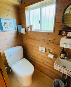 ein Badezimmer mit einer weißen Toilette und einem Waschbecken in der Unterkunft Kazenone Villa 風の音ヴィラ - A Stylish Forest Villa with Herb Garden & Cozy Fireplace in Takashima