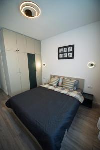 a bedroom with a large black bed with pillows at Bruno Apartment in Arad
