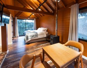 a bedroom with a bed and a table and chairs at Pousada Amigos da Montanha in Urubici