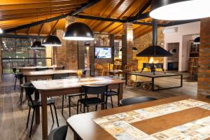 a restaurant with tables and chairs and a fireplace at Pousada Amigos da Montanha in Urubici