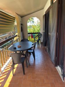 a patio with a table and chairs on a balcony at Appartamento a Marina di San Nicola Roma in Palo