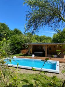 a swimming pool in the yard of a house at Gîtes & Spa de charme " Ploum" in Pouydesseaux