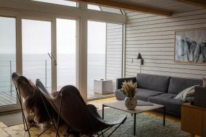 a living room with a couch and a table at Ilimanaq Lodge - World of Greenland - 1 hour boat trip from Ilulissat in Ilmanaq +10 photos