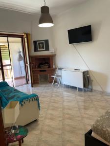 a living room with a couch and a tv on the wall at Appartamento a Marina di San Nicola Roma in Palo