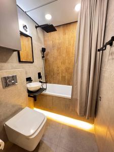 a bathroom with a toilet and a sink and a tub at 2 комнатная в историческом центре Наурызбай батыра 41 in Almaty