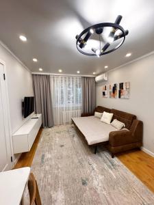 a living room with a bed and a couch at 2 комнатная в историческом центре Наурызбай батыра 41 in Almaty
