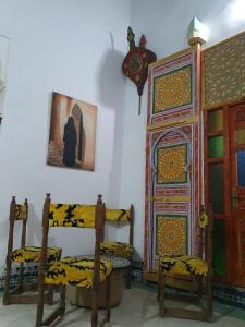 a room with two chairs and a cabinet at Riad Fes Art in Fès