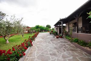a garden with red flowers and a building at Red Roses-Traditional House in Katerini