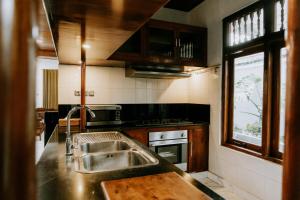 a kitchen with a sink and a stove at The Ganesha Heritage Villa in Singaraja