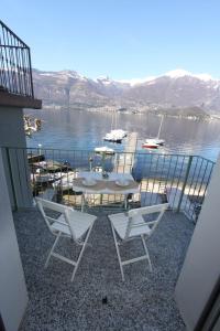 een balkon met een tafel en stoelen op het water bij Luxury Bellagio in Lezzeno