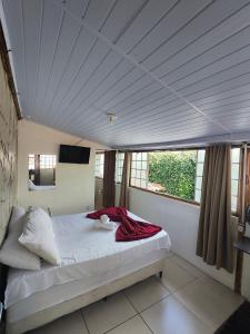 a bedroom with a bed in a room with windows at Pousada Acayaca in Diamantina