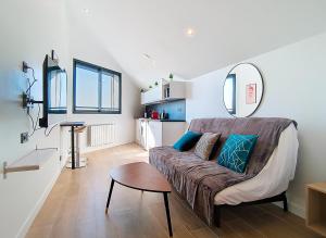 una sala de estar con un sofá y una mesa en Suite Fashion Week - Appartement central, en Argenteuil