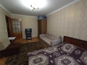 a bedroom with a bed and a chair and a television at Уютная квартира in Mekhrably +1 photo