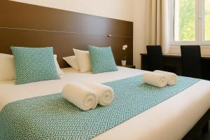 a bedroom with a bed with towels on it at Hotel & Spa Gil de France Cap d'Agde in Cap d'Agde