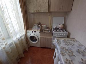 a small kitchen with a washing machine and a sink at Уютная квартира in Mekhrably