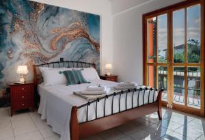 a bedroom with a bed with a painting on the wall at Villa Marina 1 in Preveza
