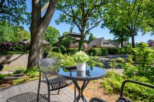 un patio con tavolo, sedie e alberi di Ankerherz Appartements bei Blankenese ad Amburgo Altre 20 foto