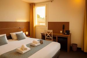 a hotel room with a bed and a desk and a window at Hotel & Spa Gil de France Cap d'Agde in Cap d'Agde
