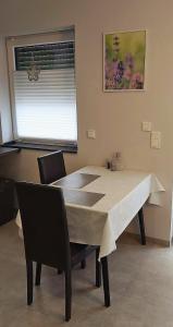 LangsurFerienwohnung am Wingertsberg的有窗户的房间里有一张桌子和几把椅子