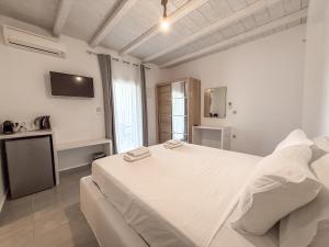 a white bedroom with a large bed and a kitchen at Villa & Suite Elia Mykonos in Mikonos +38 photos
