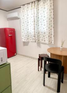 cocina con nevera roja, mesa y silla en Letters Share House, en Wonju