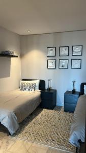 Un dormitorio con una cama con dos mesitas de noche y dos mesas. en Le Balcon du Port, en Casablanca
