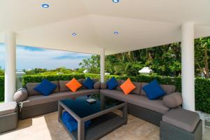 a porch with a couch with colorful pillows at Luxury Pool Villa 604 4BR 10 Persons BBQ in Nong Prue