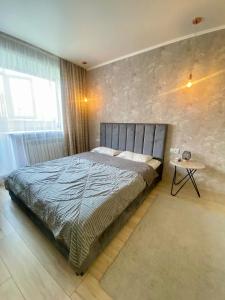 una camera da letto con un letto grande e un tavolo di Стильные апартаменты со свежим ремонтом на ЖД вокзале a Qostanay