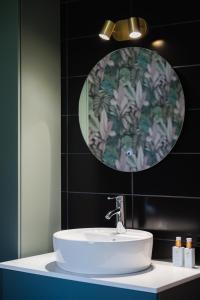 a bathroom with a white sink and a mirror at Vakantiehuisje De Barones in Middelburg +28 photos