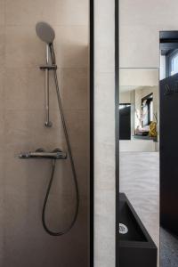 a shower with a shower head in a bathroom at Vakantiehuisje De Barones in Middelburg